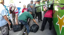 Sejumlah penumpang mengambil barang bawaannya saat turun dari bus di Terminal Pulo Gadung, Jakarta, Selasa (22/7/2015). Arus balik di Terminal Pulogadung hingga H+4 Lebaran mengalami peningkatan dibanding tahun lalu. (Liputan6.com/Faizal Fanani)