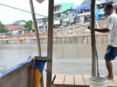 Mami (35) warga asli Kampung Pulo, Jatinegara, Jakarta Timur, merupakan generasi ke-2 penarik perahu eretan di kali Ciliwung yang memisahkan kampungnya dengan Bukit Duri, Jakarta Selatan, Rabu (28/12). (Liputan6.com/Yoppy Renato)