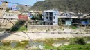 Rumah-rumah di sisi Myanmar terlihat dari balik kabel berduri yang dipasang di sepanjang tepi Sungai Tiau, perbatasan alami antara India dan Myanmar, Zokhawthar, negara bagian Mizoram (15/3/2021).  (AFP/Sajjad Hussain)