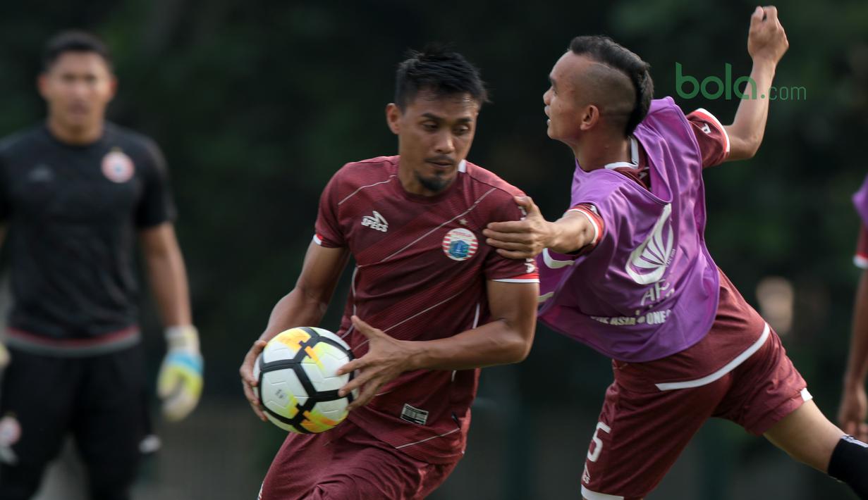 Cara Riko Simnjuntak menahan pergerakan Maman Abdurahman saat sesi latihan jelang Piala AFC 2018 di Lapangan ABC, Senayan, Jakarta, (13/3/2018). Persija akan melawan Song Lam Nghe An FC. (Bola.com/Nick Hanoatubun)