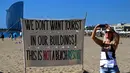 Sebuah spanduk menyerukan gerakan anti-wisatawan terpasang di pantai Barcelona, Spanyol, Sabtu (12/8). Sejumlah aktivis menunjukkan ketidakpuasan dengan meningkatnya kedatangan wisatawan ke negara di Barat Daya Eropa tersebut. (AP Photo/Manu Fernandez)