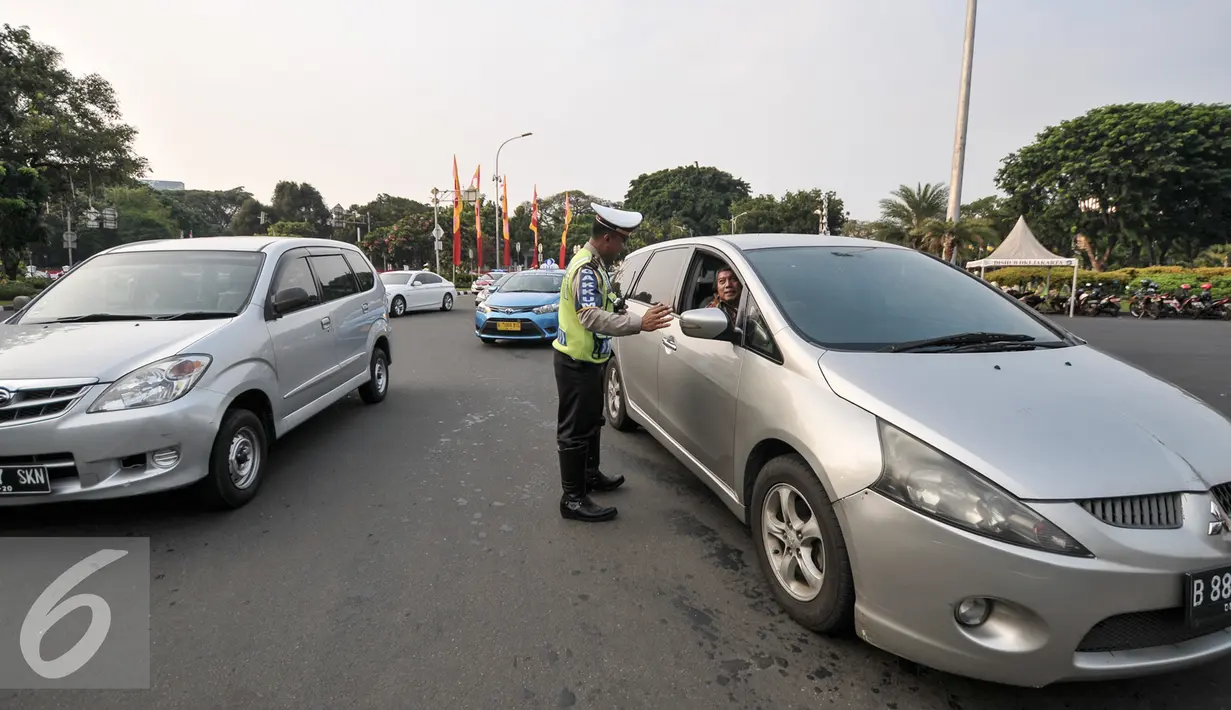 Petugas Kepolisian melakukan pencatatan jumlah mobil yang melanggar di Jalan Medan Merdeka Barat, Jakarta, Jumat (5/8). Terhitung 27 Juli hingga 3 Agustus 2016 jumlah pelanggaran uji coba ganjil-genap mencapai 5.947 pelanggar. (Liputan6.com/Yoppy Renato)