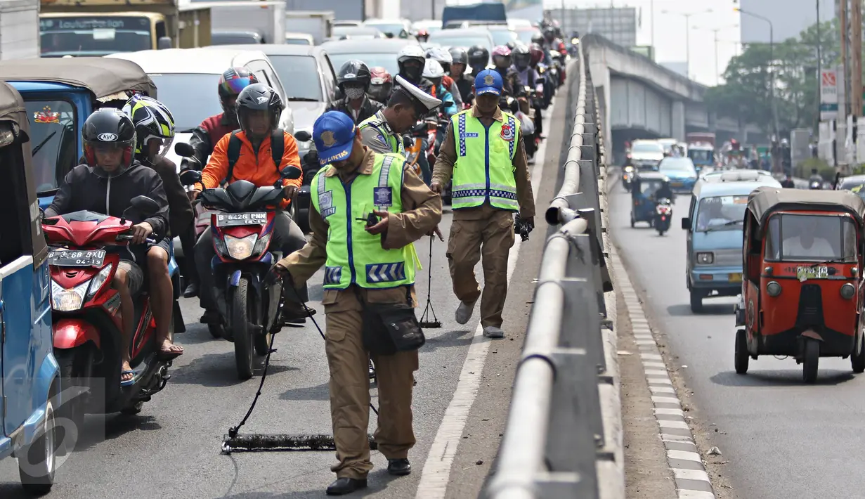 Tim Saber melakukan aksi giat sapu bersih ranjau paku di Jalan Kyai Tapa, Jakarta, Jumat (6/11). Kegiatan tersebut untuk membersihkan jalan dari ranjau paku yang banyak disebarkan oknum tidak bertanggung jawab. (Liputan6.com/Immanuel Antonius)
