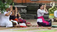 Umat Hindu memanjatkan doa saat Upacara Tawur Agung Kesanga di Pura Aditya Jaya, Pulo Gadung, Jakarta Timur, Rabu (1/3/2022). Upacara Tawur Agung merupakan simbol ritual penyucian alam semesta yang dilaksanakan sehari sebelum Catur Brata Penyepian atau Hari Suci Nyepi. (Liputan6.com/Herman Zakharia)