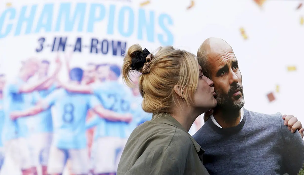 Seorang suporter Manchester City mencium papan bergambar Pep Guardiola saat merayakan gelar juara Liga Inggris di depan Stadion Etihad, Sabtu (20/5/2023). City memastikan gelar juara setelah Arsenal dikalahkan Nottingham Forest dengan skor 0-1 pada lanjutan Liga Inggris 2022/2023 hari Minggu (21/05/2023). (Martin Rickett/PA via AP)