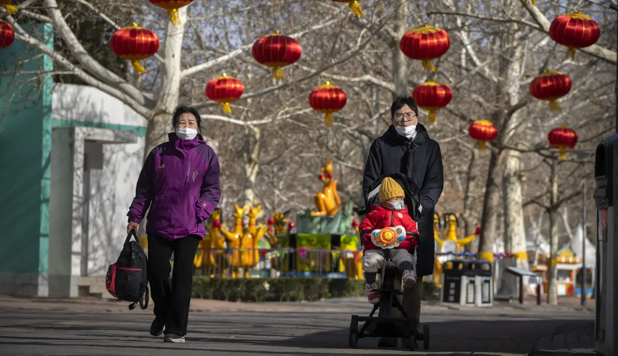 Seorang pria mendorong seorang anak di kereta bayi di sebuah taman umum di Beijing, Selasa (17/1/2023). Dalam jangka panjang, para pakar PBB melihat populasi China menyusut hingga 109 juta pada tahun 2050. (AP Photo/Mark Schiefelbein)