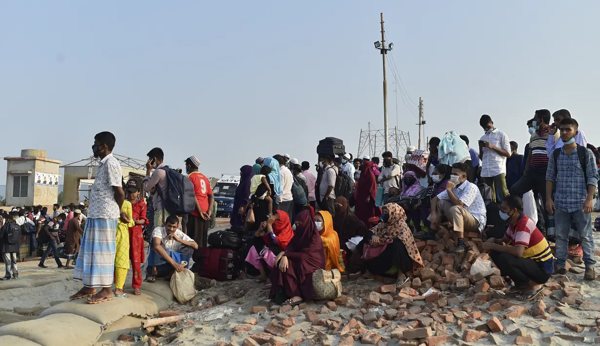 Orang-orang menunggu kedatangan kapal feri menuju kampung halaman menjelang perayaan Idul Fitri di tengah pandemi Covid-19 di Munshiganj, Bangladesh pada 9 Mei 2021. Ratusan orang bergegas untuk pulang ke rumah sehingga dapat berkumpul dengan keluarga pada momen Lebaran. (Munir Uz zaman/AFP)