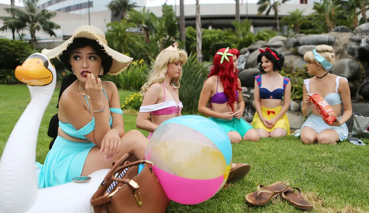 Cosplay putri-putri Disney duduk di luar San Diego Comic-Con, San Diego, California, Amerika Serikat, Jumat (20/7). Lebih dari 100 ribu cosplay diharapkan mengikuti konvensi komik dan hiburan tahunan ini. (Mario Tama/Getty Images/AFP)