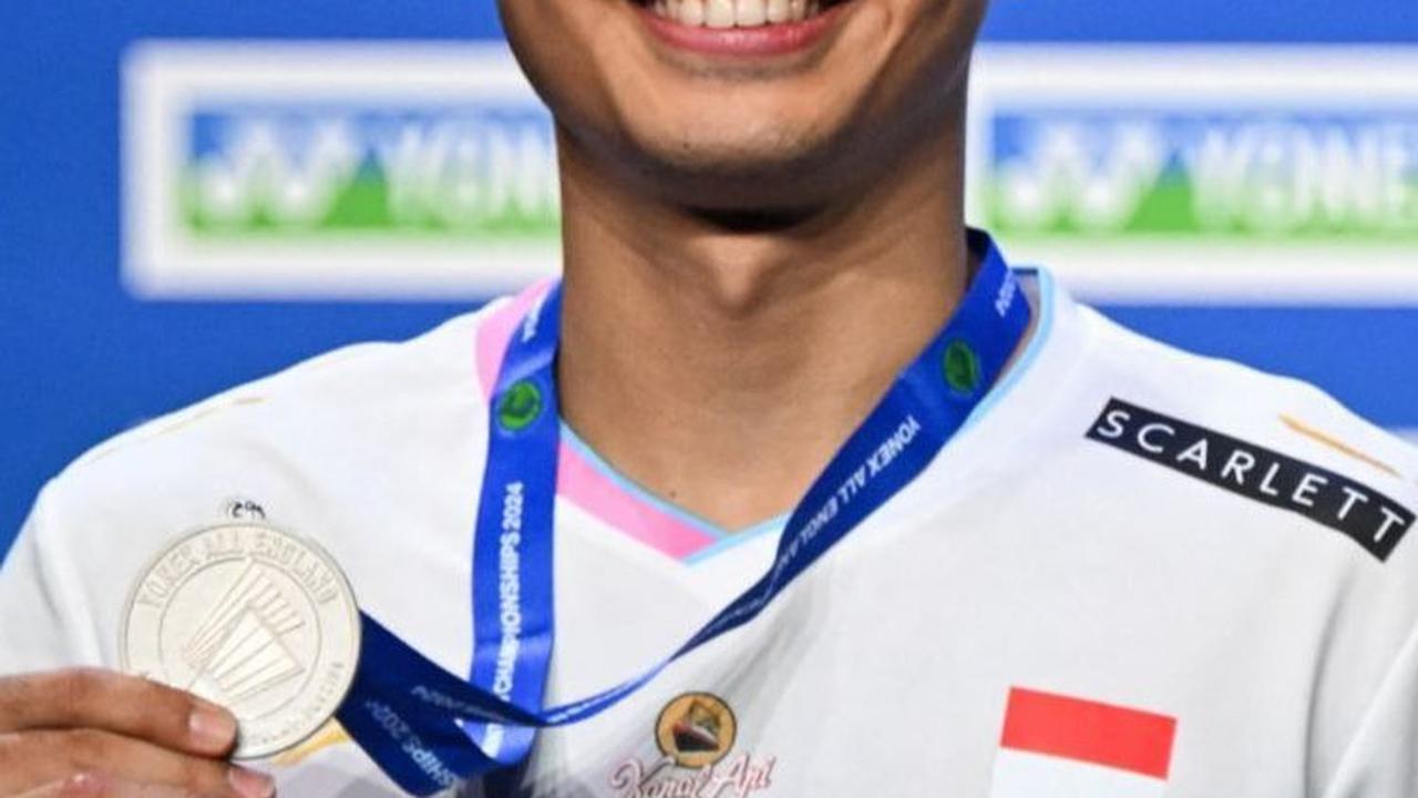 Anthony Sinisuka Ginting berpose dengan medali perak All England 2024. Foto: JUSTIN TALLIS / AFP