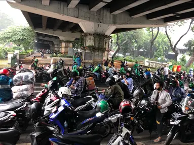 Pengendara sepeda motor berteduh di kolong flyover saat hujan mengguyur kawasan Tebet, Jakarta, Senin (14/9/2020). Kolong flyover kerap menjadi tempat berteduh bagi sebagian pengendara, meski kondisi tersebut dapat mengganggu arus lalu lintas. (Liputan6.com/Immanuel Antonius)