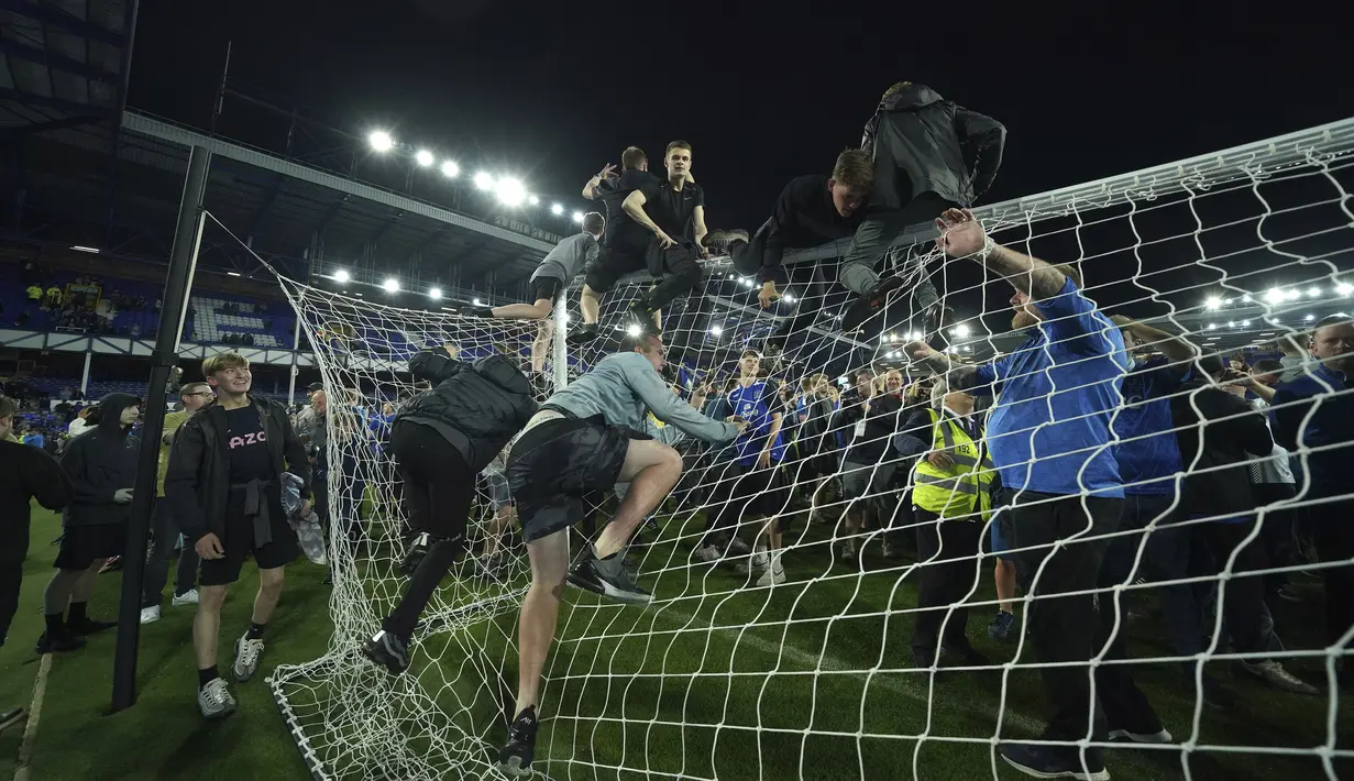 Suporter Everton menyerbu lapangan untuk merayakan akhir pertandingan Liga Inggris antara Everton dan Crystal Palace di Goodison Park di Liverpool, Inggris, 19 Mei 2022. Everton berhasil menang lewat come back dramatis 3-2 dan keluar dari zona degradasi Liga Inggris. (AP/Jon Super)