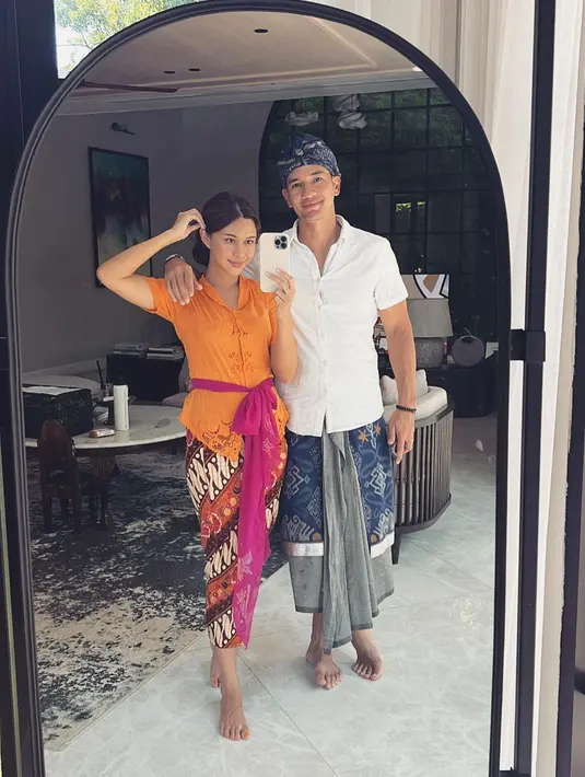 Nana Mirdad dan Andrew White merupakan pasangan seleb Indonesia yang memutuskan untuk menetap di Bali. Di foto ini, bak orang lokal, Nana mengenakan kebaya Bali lengan pendek berwarna oranye, dipasangkannya dengan kain batik sebagai bawahan, dan selendang berwarna ungu yang diikatkannya di pinggang. Sedangkan Andrew White tampil dengan kemeja lengan pendek berwarna putih, kain sebagai bawahan, lengkap dengan selendang, dan udengnya yang bernuansa biru-abu-abu senada. Foto: Instagram.