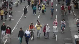 Sejumlah peserta Car Free Day (CFD) berjalan santai di kawasan Bundaran HI, Jakarta, Minggu (8/5/2016). Walaupun libur panjang, warga Jakarta masih antusias melakukan aktivitas di hari bebas berkendaraan untuk berolahraga. (Liputan6.com/Faizal Fanani)