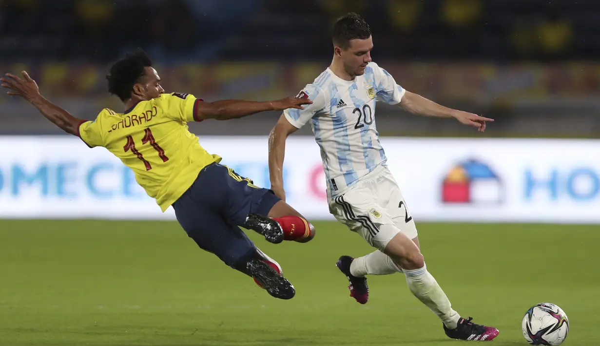 Gelandang Argentina, Exequiel Palacios menggiring bola melewati gelandang Kolombia, Juan Cuadrado pada laga lanjutan Kualifikasi Piala Dunia 2022 Zona Amerika Selatan di Stadion Metropolitano, Rabu (9/6/2021) pagi WIB. Argentina bermain imbang 2-2 dengan Kolombia. (AP Photo/Fernando Vergara)