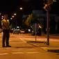 Seorang polisi berjaga di sebuah jalan di dekat pusat perbelanjaan Olympia Einkaufzentrum (OEZ) di Munich, Jerman (22/7). Penembakan ini hanya berselang tiga hari setelah terjadinya penyerangan di kereta api Jerman. (AFP PHOTO/Christof Stache)