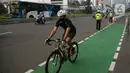 Pesepeda melewati polisi yang melakukan penertiban di kawasan Sudirman-Thamrin, Jakarta Pusat, Rabu (2/6/2021). Wakil Gubernur DKI Jakarta Ahmad Riza Patria mengatakan, sepeda road bike diperbolehkan untuk melintas di Jalan Sudirman-Thamrin pada hari kerja Senin-Jumat. (Liputan6.com/Faizal Fanani)