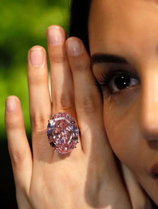 Seorang model mengenakan berlian "The Pink Star" sebelum dilelang oleh Sotheby di London, 20 Maret 2017. Pada 2013, The Pink Star pernah terjual seharga US$83 juta di Jenewa, dan menjadi berlian termahal yang pernah dilelang (AP Photo/Kirsty Wigglesworth)