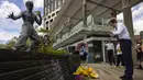<p>Para penggemar berkumpul di depan patung seniman bela diri Bruce Lee untuk memperingati 50 tahun kematiannya di Hong Kong, Kamis, 20 Juli 2023. (AP Photo/Louise Delmotte)</p>
