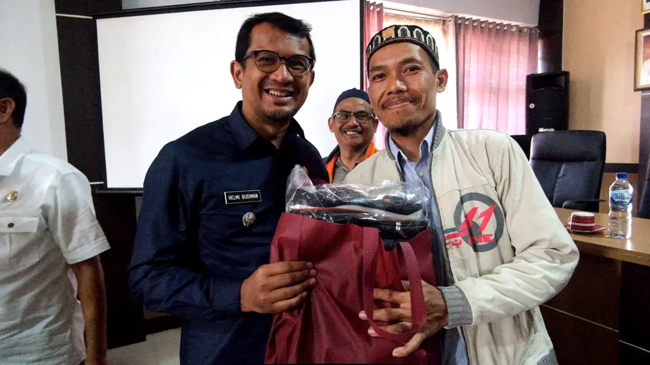 Wabup Garut Helmi Budiman, secara simbolis memberikan seperangkat alat pemotongan kepada salah satu peserta calon penyembelih hewan qurban secara profesioanal di Garut. (Liputan6.com/Jayadi Supriadin)