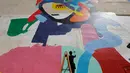 Tarsila Schubert menggunakan tangga membuat karya mural di dinding Museum Seni Terbuka, Kota Amman, Yordania, Kamis (29/9). Mural karya Tarsila Schubert asal Brasil itu menghiasi Museum Seni Terbuka, Kota Amman, Yordania. (REUTERS/Muhammad Hamed)