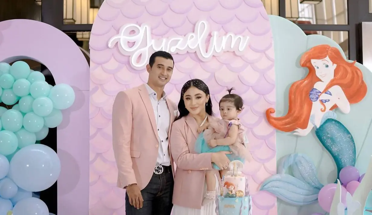 Tampil kompak dengan busana bernuansa pink, momen ulang tahun Baby Guzel yang pertama ini dirayakan di sebuah hotel dengan konsep Little Mermaid. Dalam media sosial Instagram keduanya, Ali Syakieb dan Margin Wieheerm pun tampil penuh perasaan bahagia saat ulang tahun anaknya tersebut dihadiri oleh sejumlah sahabat dan keluarga. (Liputan6.com/IG/@alisyakieb)