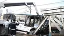 Petugas mengamati evakuasi bus transjakarta usai ditabrak kereta Senja Utama Solo di perlintasan Jalan Mangga Dua, Jakarta, Kamis (19/5). Menurut keterangan, insiden itu disebabkan bus Transjakarta yang menerobos palang pintu. (Liputan6.com/Faizal Fanani)
