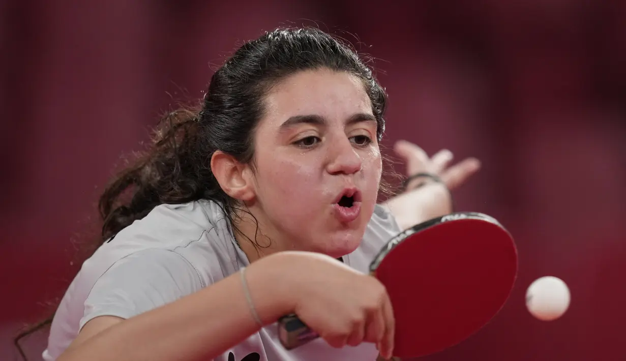 Petenis meja Suriah Hend Zaza mengembalikan pukulan Liu Jia dari Austria selama pertandingan babak penyisihan tunggal tenis meja putri di Olimpiade 2020 di Tokyo, Sabtu (24/7/2021). Zaza lolos ke olimpiade usai menjadi juara turnamen kualifikasi zona Asia Barat pada Februari 2020 silam. (AP Photo/Ki