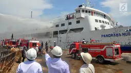 Pemadam kebakaran berusaha memadamkan api yang membakar kapal Panorama Nusantara di Pelabuhan Tanjung Mas, Semarang, Senin (18/2). Angin kencang membuat api semakin cepat membesar. (Liputan6.com/Gholib)