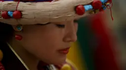 Seorang wanita Tibet mengunakan pakaian tradisional berdoa saat perayaan ulang tahun ke-80 Dalai lama di Kathmandu, Nepal (6/7/2015). Pemeluk Buddha Tibet percaya, Dalai Lama adalah perwujudan insani dari Avalokitesvara. (REUTERS/Navesh Chitrakar)