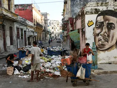 Warga Kuba mengumpulkan bahan mentah dari sejumlah besar sampah di sebuah jalan di Havana pada 23 Agustus 2024. (YAMIL LAGE / AFP)