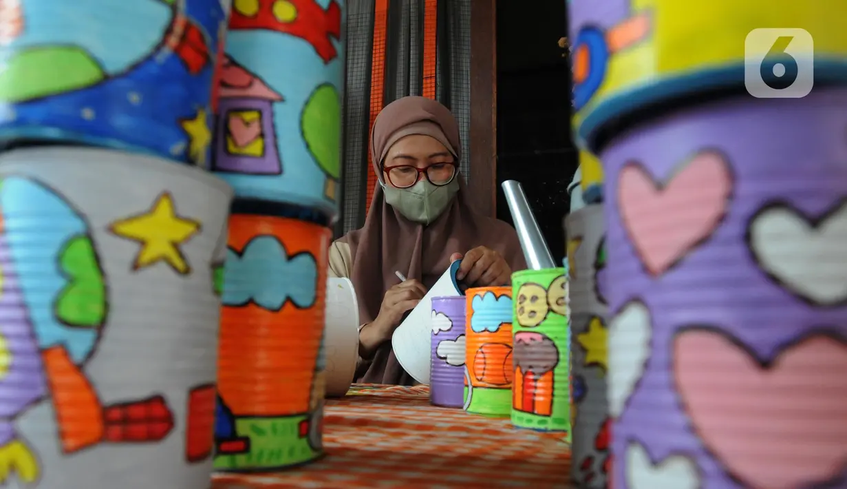 Perajin melukis bahan daur ulang untuk dipasarkan secara online di Kaleng Lani  di kawasan Tanah Baru, Depok, Jawa Barat, Rabu (9/3/2022). Setiap bulannya perajin mampu memberikan pendapatan ekonomi keluarga antara Rp 5 juta hingga Rp 7,5 juta. (merdeka.com/Arie Basuki)