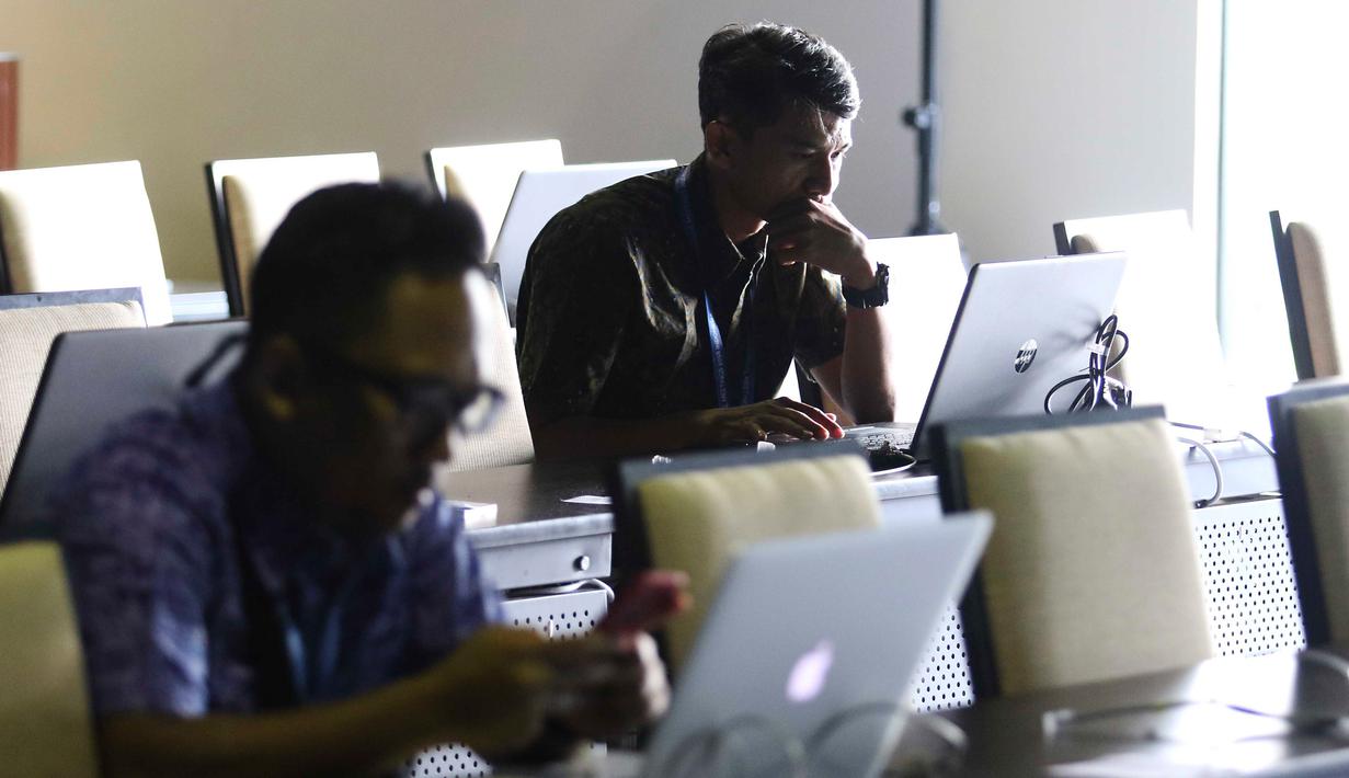 Jurnalis berbagai negara mengetik berita pertemuan tahunan IMF-Bank Dunia di Nusa Dua, Bali, Senin (8/10). Menkominfo Rudiantara memastikan fasilitas internet kencang untuk tamu dan media dalam pertemuan tahunan ini. Liputan6.com/Angga Yuniar)