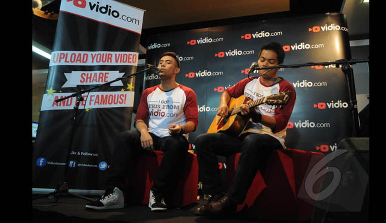 Pemenang ketiga dan kedua Music Video Contest, Eros Tjokro  (kiri) dan Dibya Dika (kanan) saat berduet di kantor Vidio.com, SCTV Tower, Jakarta, Rabu (28/1/2015). (Liputan6.com/Herman Zakharia)