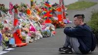 Seorang pelajar termenung saat menggelar mengenang korban penembakan di luar Masjid Al Noor, Christchurch, Selandia Baru, Senin (18/3). Penembakan tersebut merupakan serangan terburuk dalam sejarah Selandia Baru modern. (AP Photo/Vincent Yu)