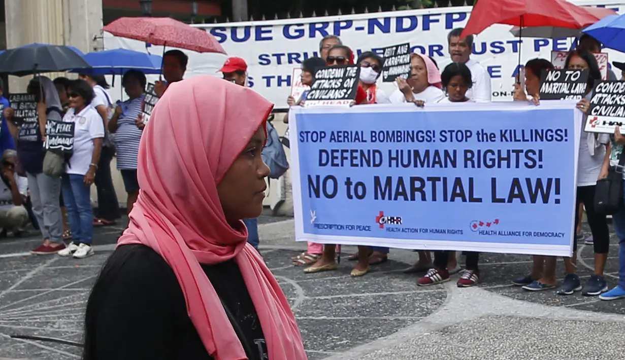 Sejumlah orang menggelar aksi protes terhadap  deklarasi Darurat Perang oleh Presiden Duterte di wilayah selatan Mindanao, Manila, Filipina, Kamis (8/6). deklarasi tersebut menurut mereka hanya akan menimbulkan pelanggaran HAM. (AP Photo / Bullit Marquez)