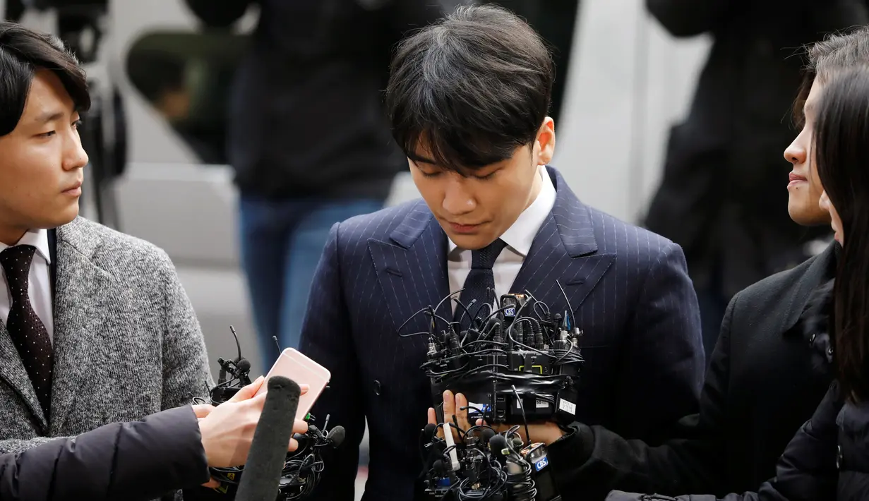 Kpop Idol, Seungri menjawab pertanyaan wartawan setibanya di Kantor Polisi Metro Seoul, Kamis (14/3). Sebelum melayani pertanyaan para wartawan, Seungri membungkukkan badannya 90 derajat beberapa detik. (REUTERS/Kim Hong-Ji)