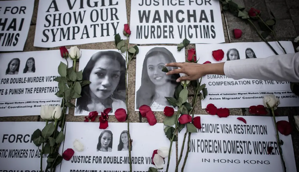 Sejumlah bunga mawar diletakkan di atas foto Sumarti Ningsih dan Seneng Mujiasih, Hong Kong, Minggu (9/11/2014). (AFP PHOTO/Philippe Lopez)