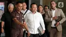 Mantan Direktur Jenderal (Dirjen) Imigrasi Kementerian Hukum dan Hak Asasi Manusia (Kemenkumham), Ronny Franky Sompie (tengah) usai menjalani pemeriksaan di Gedung Komisi Pemberantasan Korupsi (KPK), Jakarta, Jumat (3/1/2025). (Liputan6.com/Herman Zakharia)