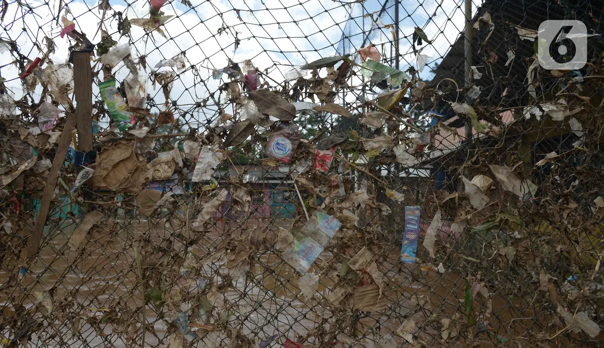 Sampah sisa banjir menyangkut pada jaring di Kelurahan Rawa Jati, Jakarta, Selasa (9/2/2021). Luapan Kali Ciliwung menyisakan sampah dan endapan lumpur. (merdeka.com/Imam Buhori)