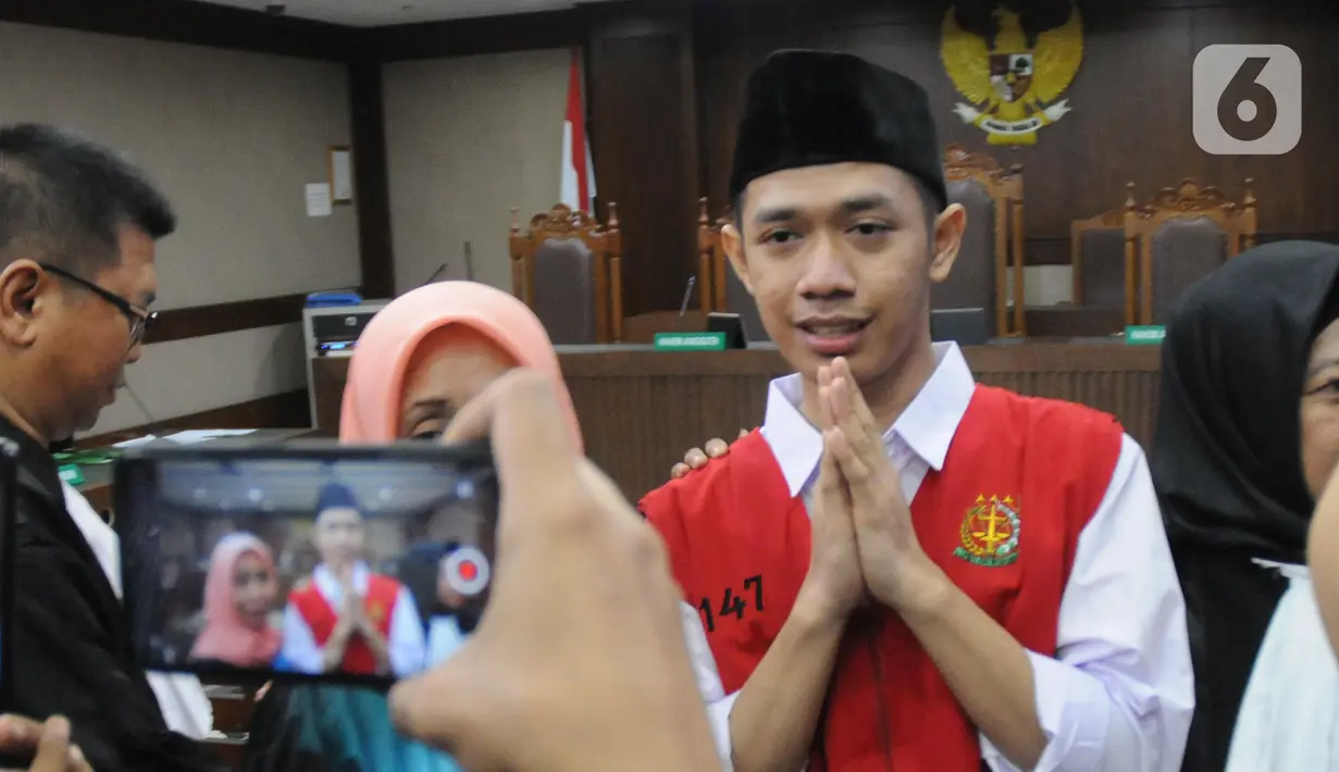Dede Luthfi Alfiandi, pembawa bendera Merah Putih saat aksi siswa SMK di kawasan DPR/MPR RI pada September lalu, menjawab pertanyaan pewarta jelang sidang perdana di Pengadilan Negeri Jakarta Pusat, Kamis (12/12/2019). Sidang mendengar pembacaan dakwaan. (Liputan6.com/Helmi Fithriansyah)