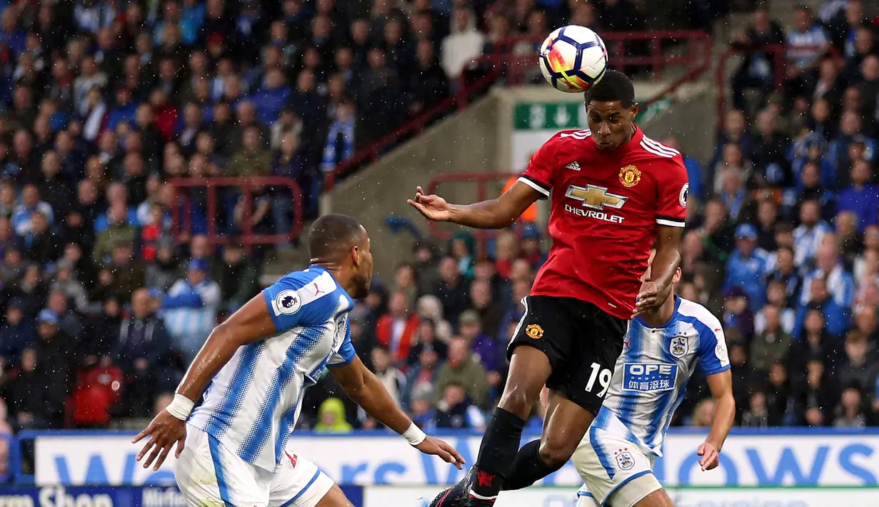 Pemain Manchester United Marcus Rashford melakukan sundulan yang akhirnya berbuah gol saat melawan Huddersfield dalam pertandingan Liga Inggris di stadion John Smith di Huddersfield (21/10). (Nigel French / PA via AP)