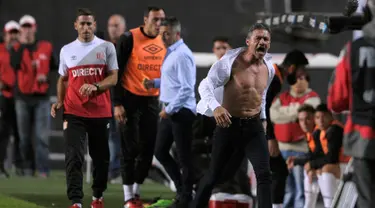 Pelatih klub Estudiantes, Nelson Vivas menyobek kemejanya sambil marah memprotes keputusan wasit Silvio Trucco mengkartu merahkan dirinya di pertandingan melawan Boca Juniors di stadion Ciudad de La Plata, Argentina (6/5). (AFP Photo/Alejandro Pagni)