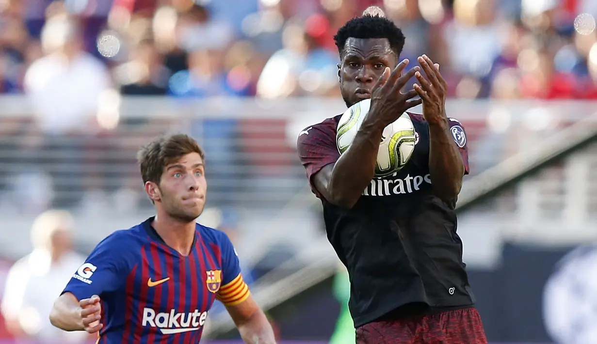 Gelandang AC Milan Franck Kessie mengontrol bola dari kawalan bek pemain Barcelona saat bertanding pada International Champions Cup di Levi's Stadium di Santa Clara, California (4/8). Milan menang tipis 1-0 atas Barcelona. (AFP Photo/Lachlan Cunningham)