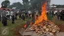 Petugas saat membakar kemasan ganja di Mapolsek Palmerah, Jakarta Barat, Senin (15/6/2015). Barang bukti yang dimusnahkan berupa 10.286 botol miras, 561 kg ganja, 1,4 kg sabu, 7.668 butir ekstasi, 1.000 butir psikotropika. (Liputan6.com/Johan Tallo)