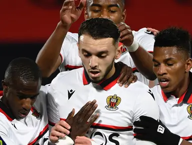 Striker Nice, Amine Gouiri (tengah) melakukan selebrasi usai mencetak gol pertama timnya melalui eksekusi penalti ke gawang Rennes dalam laga lanjutan Liga Prancis 2020/21 pekan ke-27 di Roazhon Park Stadium, Rennes, Jumat, (26/2/2021). Nice menang 2-1 atas Rennes. (AFP/Damien Meyer)