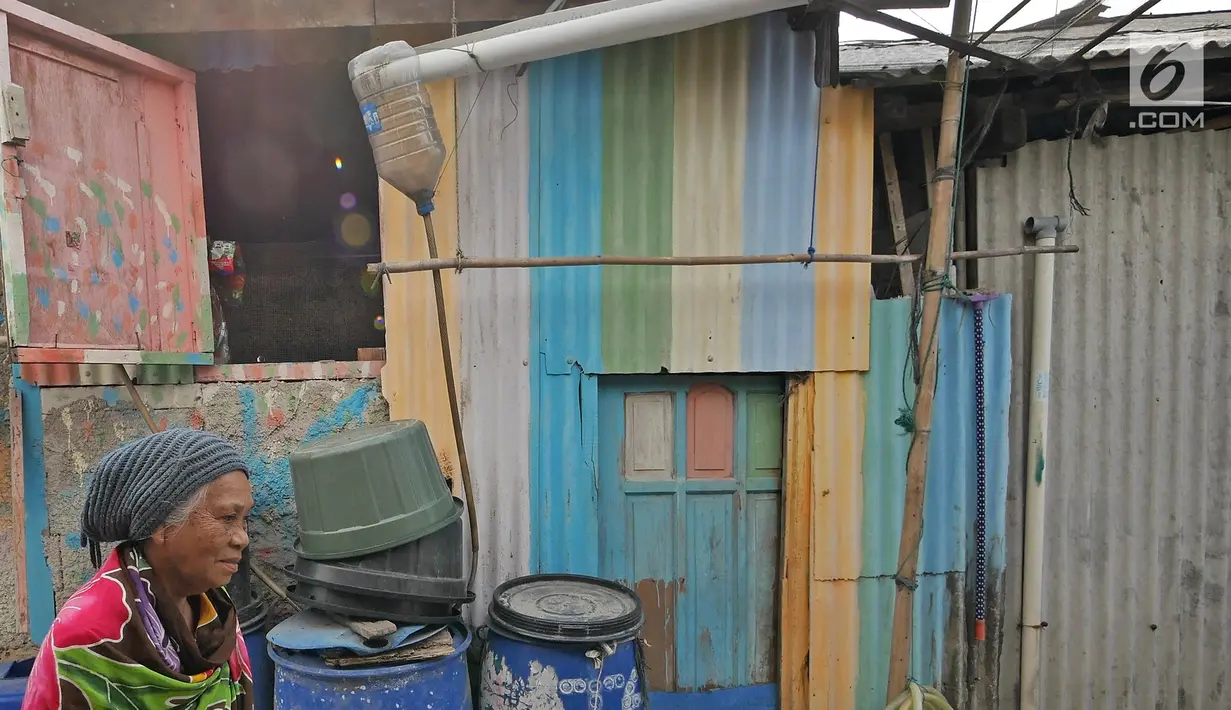 Warga berjalan melewati talang yang menyalurkan air ke dalam tong di kawasan Kampung Kamal Muara, Jakarta, Selasa (9/7/2019). Saat musim kemarau, warga Kampung Kamal Muara harus membeli air seharga Rp 5.000 per jeriken untuk kebutuhan mandi, cuci pakaian dan lain-lain. (Liputan6.com/Herman Zakharia)