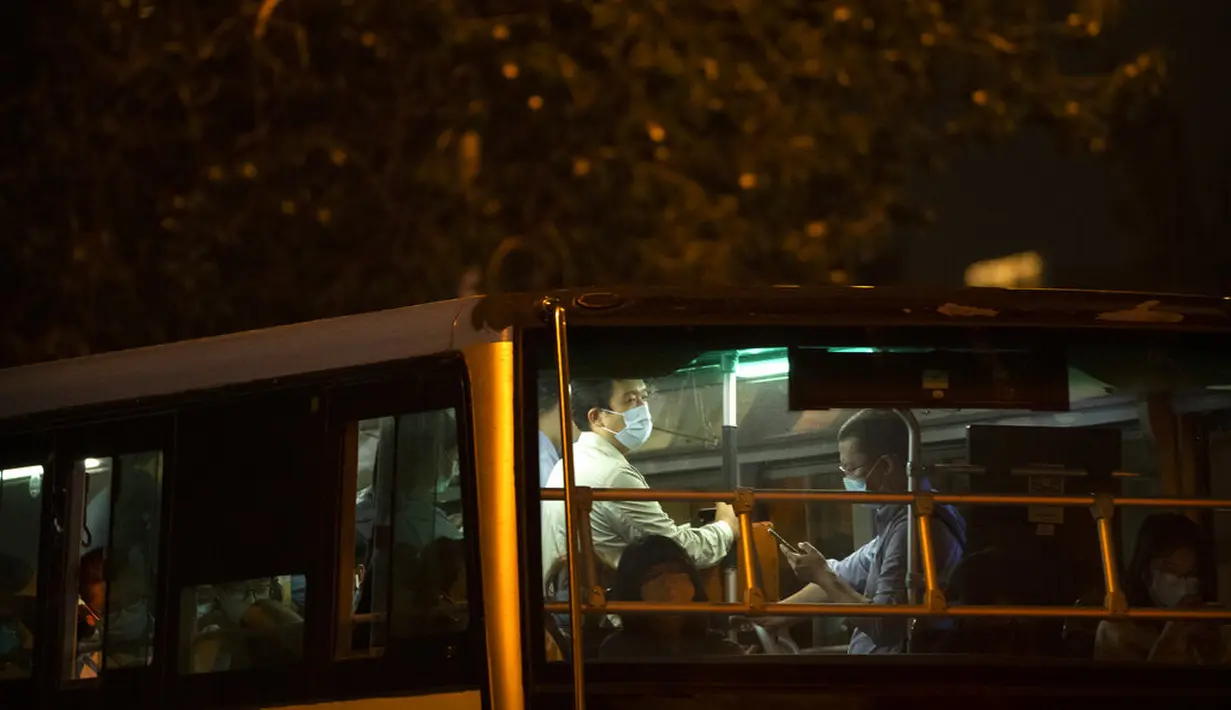 Seorang pria yang mengenakan masker untuk melindungi diri dari COVID-19 mengendarai bus umum di Beijing, Rabu (15/9/2021). China memperketat penguncian dan meningkatkan pesanan untuk pengujian massal di kota sepanjang pantai timurnya di tengah lonjakan kasus COVID-19. (AP Photo/Mark Schiefelbein)