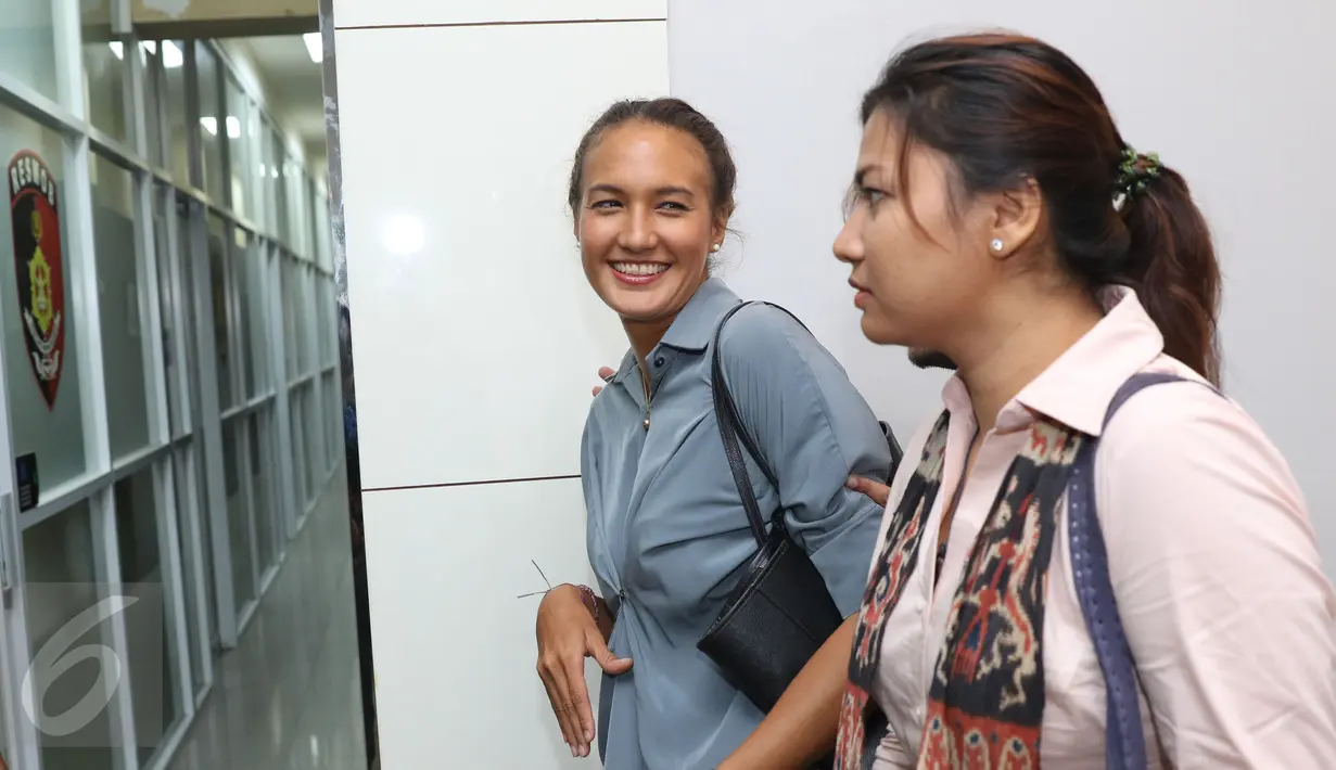 Senyum Putri Indonesia 2005, Nadine Chandrawinata setibanya di Gedung Subdit Resmob Polda Metro Jaya, Jakarta, Senin (19/9). Nadine menjalani pemeriksaan sebagai saksi terkait kepemilikan senjata api ilegal Gatot Brajamusti. (Liputan6.com/Herman Zakharia)