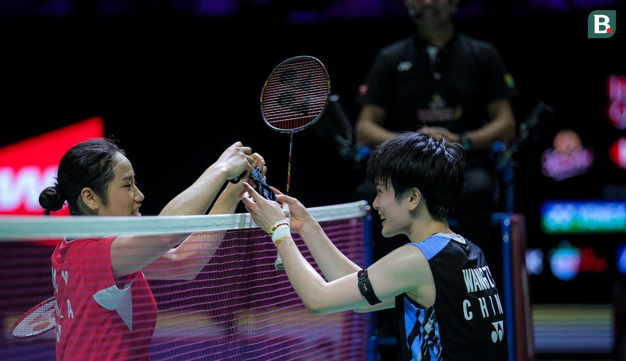 Pebulu tangkis tunggal putri Korea Selatan, An Se Yong (kiri) bertukar bandana atau headband dengan wakil China, Wang Zhi Yi pada babak semifinal Indonesia Open 2024 di Istora Senayan, Jakarta, Sabtu (08/06/2024). (Bola.com/Bagaskara Lazuardi)