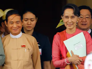 Presiden Myanmar yang baru terpilih Win Myint dan pemimpin Myanmar Aung San Suu Kyi meninggalkan gedung parlemen di Naypyitaw, Rabu (28/3). Sekutu dekat Aung San Suu Kyi ini telah terpilih sebagai presiden baru Myanmar oleh parlemen. (AP/Aung Shine Oo)